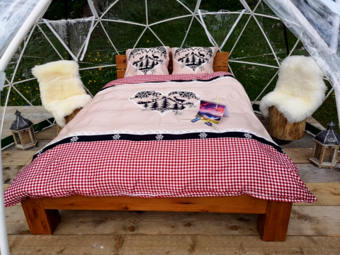 Glamping en Bubbelreis - Glazen Iglo Isenthal con cama acogedora, sillas, linternas y domo en la naturaleza.