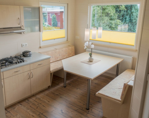 Moderne keuken en eetruimte in glampingaccommodatie van Ferienanlage Erzeberg - Blockhütten Hessen.