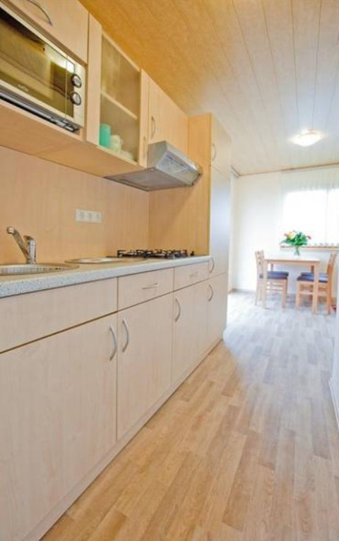 Cuisine moderne à Ferienanlage Erzeberg - Blockhütten Hessen avec coin repas lumineux à l’arrière-plan.