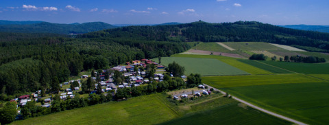 Vista aerea del campeggio o glamping Ferienanlage Erzeberg - Blockhütten Hessen immerso nel verde e nei boschi.