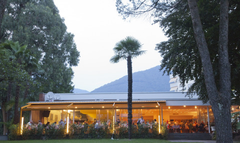 Udendørs restaurant på Campofelice Camping Village - Igloo Tube Lago Maggiore omgivet af træer og bjerge