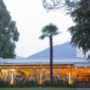 Outdoor dining area at Campofelice Camping Village - Igloo Tube Lago Maggiore with mountain backdrop