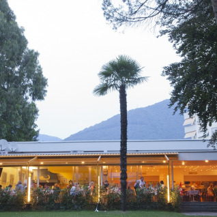 Udendørs restaurant på Campofelice Camping Village - Igloo Tube Lago Maggiore omgivet af træer og bjerge