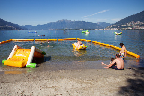 Kinderen spelen op opblaasbare waterstructuren bij Campofelice Camping Village aan het Lago Maggiore.