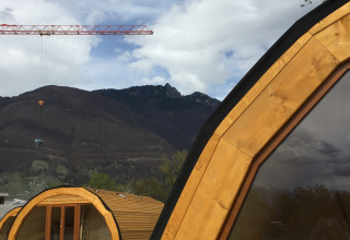 Glamping al Campofelice Camping Village - Igloo Tube Lago Maggiore con casette in legno e montagne.