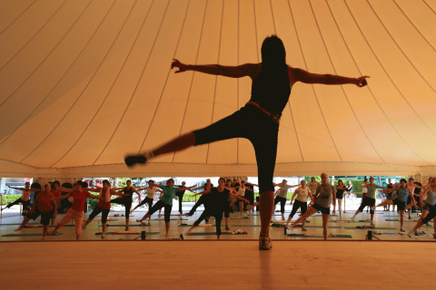 Fitnessklasse under et telt på Campofelice Camping Village - Igloo Tube Lago Maggiore med mange deltagere.