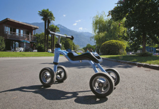 Firehjulet løbecykel på vej foran Campofelice Camping Village - Igloo Tube ved Lago Maggiore, Schweiz.