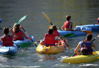 Des enfants font du kayak sur le lac du Campofelice Camping Village - Igloo Tube Lago Maggiore au soleil.