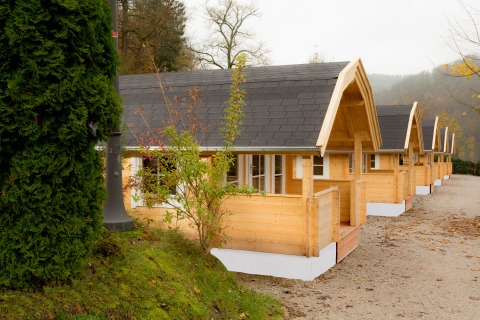 Row of modern wooden glamping cabins at Campingpark Wiesenbeker Teich, set in scenic surroundings in Lower Saxony.