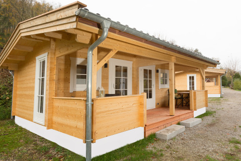 Cabane en bois glamping au Campingpark Wiesenbeker Teich avec terrasse dans un cadre naturel paisible.