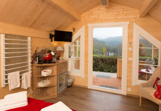 Vista interna di una confortevole casetta glamping al Campingpark Wiesenbeker Teich con panorama sulle colline.