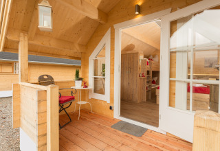 Udendørs træterrasse og hyggelig indretning i glampinghytte ved Campingpark Wiesenbeker Teich.