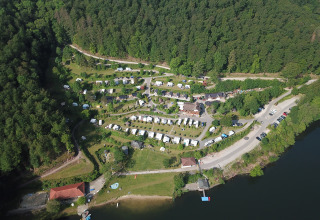 Vista aérea de Campingpark Wiesenbeker Teich junto a un lago y bosque, con tiendas y cabañas en Baja Sajonia.