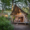 Glamping accommodation in the woods at Huttopia Rambouillet - Glamping île de France, two people relaxing outside.