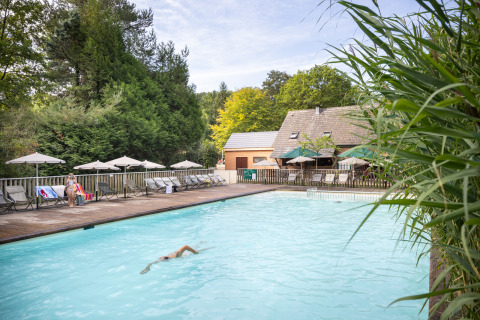 Piscina al aire libre en Huttopia Rambouillet - Glamping île de France, rodeada de árboles y tumbonas