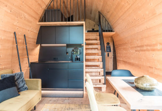 Luxuriöses Chalet bei Alpencamping Nenzing in Vorarlberg mit modernem schwarzen Küchenbereich und Holzinterieur.