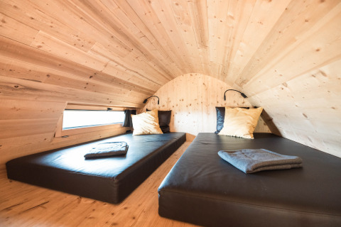 Vista interna di uno chalet glamping di lusso in legno con due letti ad Alpencamping Nenzing, Vorarlberg.