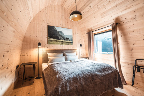 Chalet di lusso ad Alpencamping Nenzing in Vorarlberg con pareti in legno, letto matrimoniale e finestra.