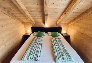 Acogedor dormitorio en alojamiento glamping en Camping & Vakantiepark Orsingen, Landhuis Baden-Württemberg.