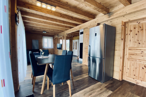 Moderne glampingaccommodatie met houten interieur, eettafel en keuken bij Camping & Vakantiepark Orsingen.