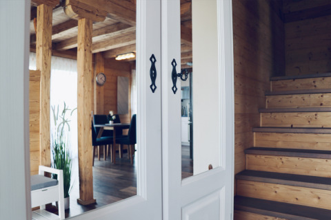 Interior view of cozy wooden glamping house with stairs, dining area, and natural light in Orsingen.