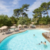 Outdoor swimming pool with sun loungers and umbrellas at Camping Huttopia Arcachon - Glamping Nouvelle-Aquitaine.