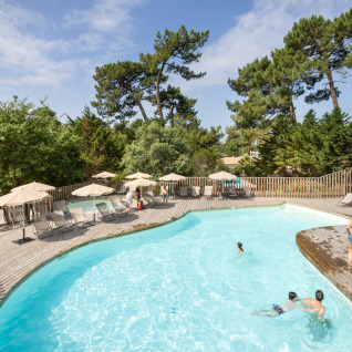 Udendørs swimmingpool med solsenge og parasoller på Camping Huttopia Arcachon - Glamping Nouvelle-Aquitaine.