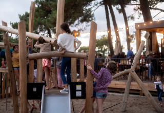 Kinderen spelen op een houten speeltuin bij Camping Huttopia Arcachon - Glamping Nouvelle-Aquitaine in het bos.