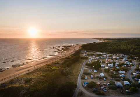 Luftfoto af glamping-indkvartering på Huttopia Ars-en-Ré ved stranden i Nouvelle-Aquitaine, Frankrig ved solnedgang.