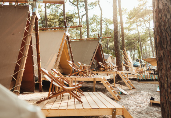 Tende glamping presso Enter the wave – Forestcamp Biscarrosse, immerse nella foresta con terrazze in legno.