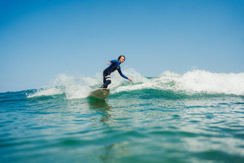 Surfer op een golf dicht bij Forestcamp Biscarrosse, ideaal voor glamping of kamperen in de natuur.