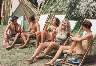 Jeunes adultes en maillot se détendent et boivent à Enter the Wave – Forestcamp Biscarrosse en pleine nature.