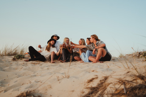 Vriendengroep proost samen op de zandduinen bij Enter the wave – Forestcamp Biscarrosse glamping.
