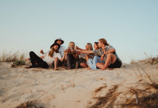 Un gruppo di amici si diverte tra le dune di sabbia al glamping Enter the wave – Forestcamp Biscarrosse.