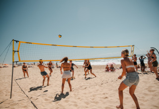 Des personnes jouent au volley-ball sur la plage ensoleillée du glamping Enter the wave – Forestcamp Biscarrosse.