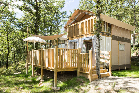 Hébergement glamping à deux étages au Vallicella Glamping Resort en Toscane, entouré de forêt verdoyante.