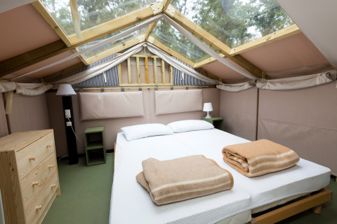 Lys og komfortabel Airlodge med dobbeltseng og ovenlys i Vallicella Glamping Resort i Toscana.