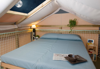 Hébergement glamping confortable avec lit, puits de lumière et vue sur la lune au Vallicella Glamping Resort.