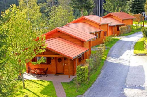 Wooden cabins at Natur-Camping Langenwald - Glampingaccomodaties Baden-Württemberg, nestled by forest.