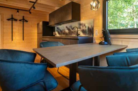 Hébergement glamping moderne au Natur-Camping Langenwald avec coin repas, kitchenette et vue sur la forêt en Baden-Württemberg.