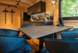 Moderne glampingaccommodatie bij Natur-Camping Langenwald met eethoek, kitchenette en boszicht in Baden-Württemberg.