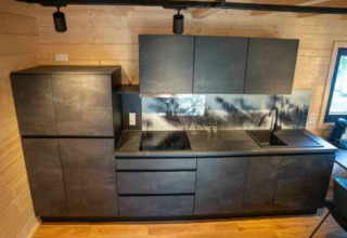 Modern black kitchen setup inside a glamping accommodation at Natur-Camping Langenwald, Baden-Württemberg.