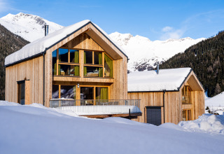 Twee moderne houten chalets met sneeuw op het dak bij HOCHoben - Chalets Oostenrijk glamping accommodatie.