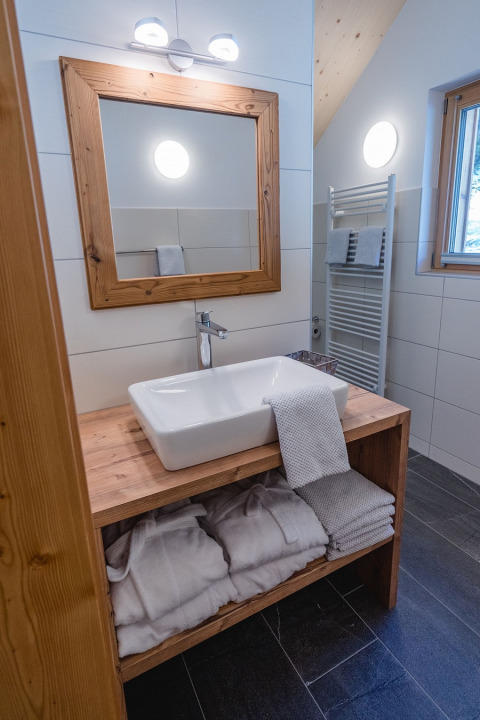 Bagno presso HOCHoben - Chalets Oostenrijk glamping, mobile in legno, lavabo moderno e asciugamani.