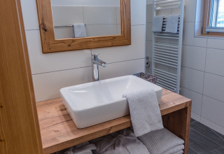 Badeværelse i HOCHoben - Chalets Oostenrijk glamping med træmøbler og moderne indretning.