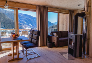 Cozy glamping accommodation at HOCHoben - Chalets Oostenrijk with mountain view, wood stove, and modern decor.