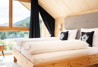 Chambre lumineuse de HOCHoben - Chalets Oostenrijk avec design en bois moderne et vue sur les montagnes.