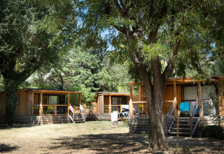 Glamping accommodatie bij Huttopia Le Moulin - Glamping Ardèche tussen de bomen op een zonnige locatie.