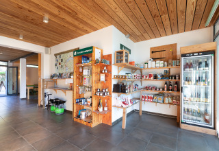 Indoor shop view at Huttopia Winter Chalets – Divonne Les Bains with groceries, drinks, and camping supplies.