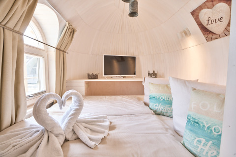 Cozy glamping accommodation at Iglu Camp Tangermünde, Saxony-Anhalt, featuring a stylish bed and decor.